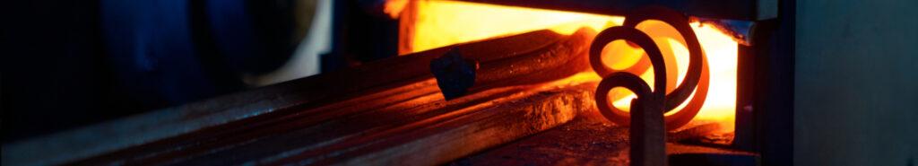 Schmiedefeuer mit glühendem Metallstab in einem Ofen.